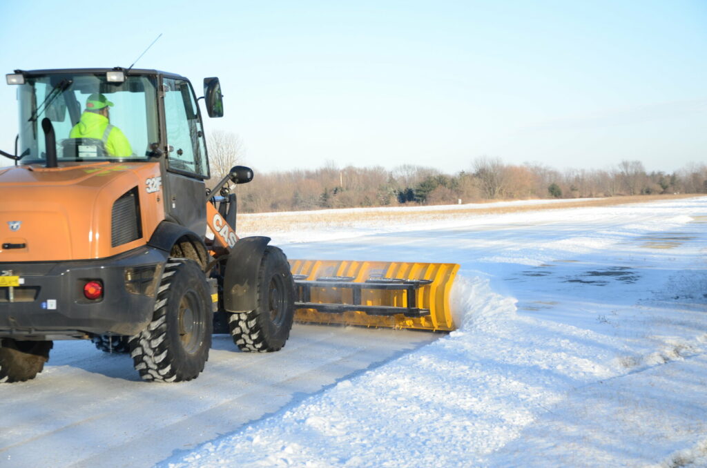 arctic snow and ice sectional snow plow plowing snow behind