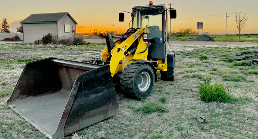 compact-wheel-loader-with-attachment-in-field-in-western-canada-rentals