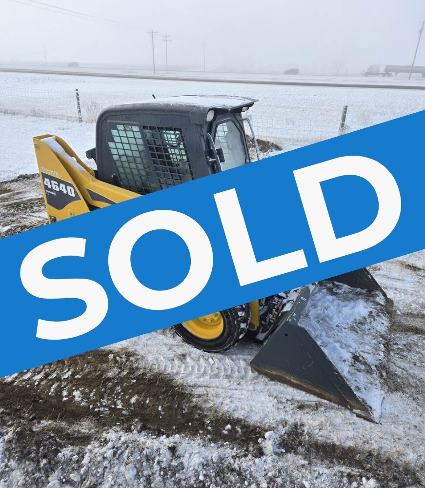 Angled-view-of-a-Gehl-4640-skid-steer-loader-showing-its-protective-cab-tires-with-snow-grip-and-bucket-attachment.-Perfect-for-farming-and-construction-use-in-Western-Canada-sold