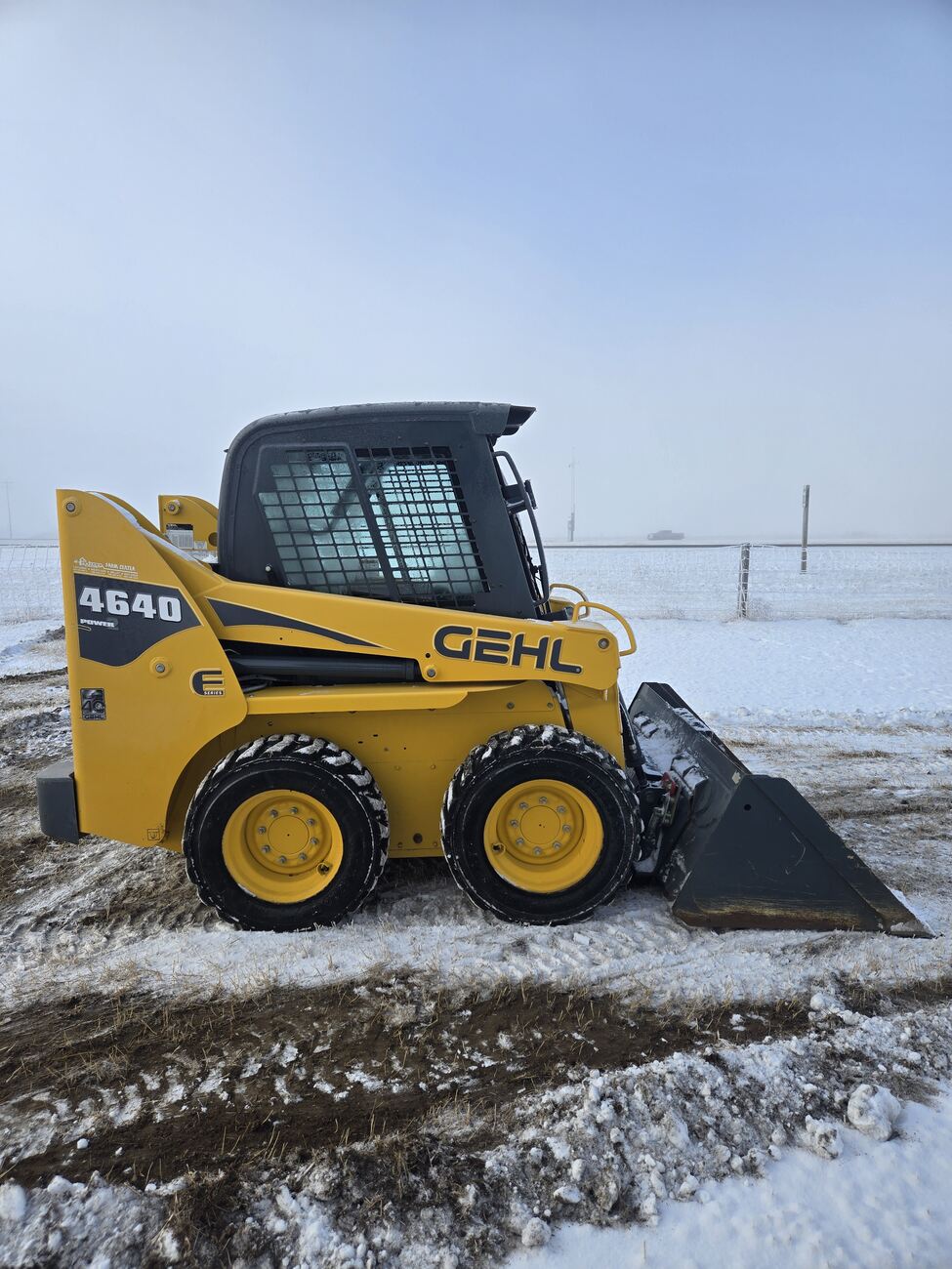 Full side profile of a Gehl 4640 skid steer loader with a bucket attachment, designed for efficient material handling and construction work. For sale in Western Canada.jpg
