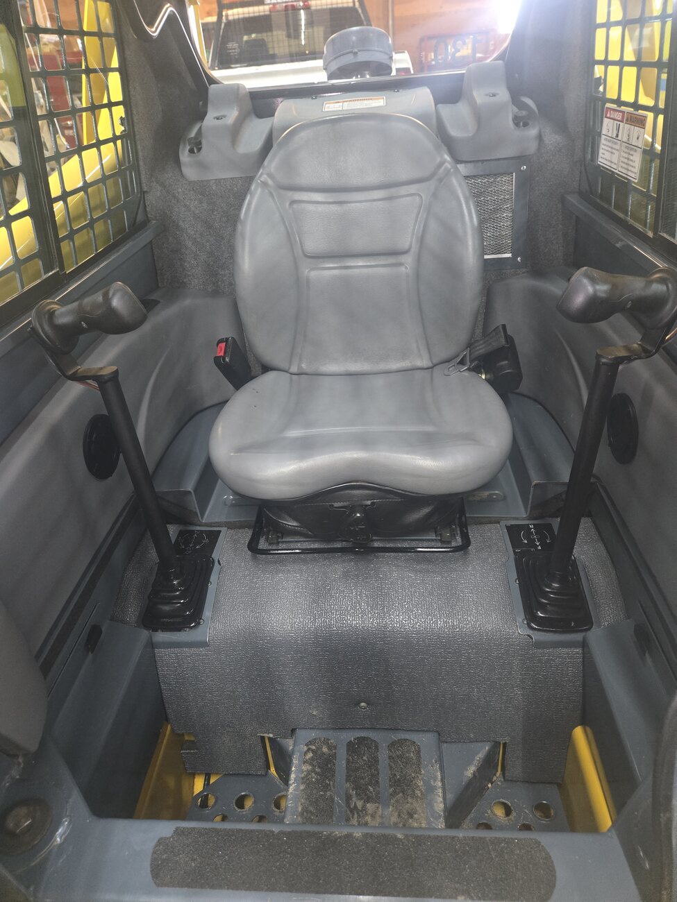 Inside cabin view of a Gehl 4640 skid steer loader Comfortable and well-maintained for efficient operation. Located in Western Canada