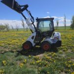 2022-bobcat-l28-small-articulated-loader-for-sale-western-canada-lifted-bucket-side-view-field