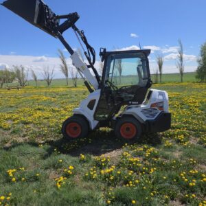2022-bobcat-l28-small-articulated-loader-for-sale-western-canada-lifted-bucket-side-view-field