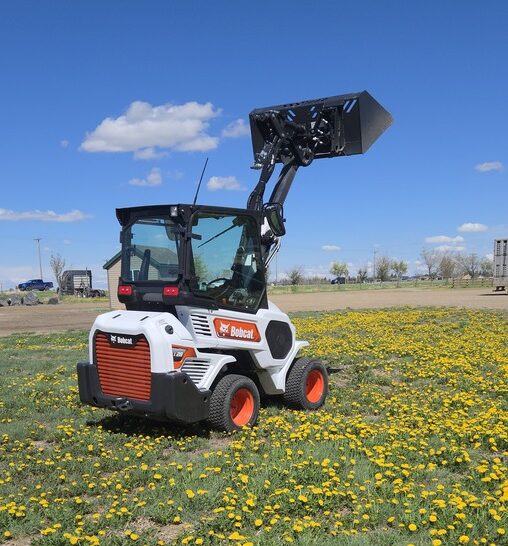 bobcat-l28-2022-loader-rear-angle-lift-arm-up-dandelion-field-western-canada-equipment-sale