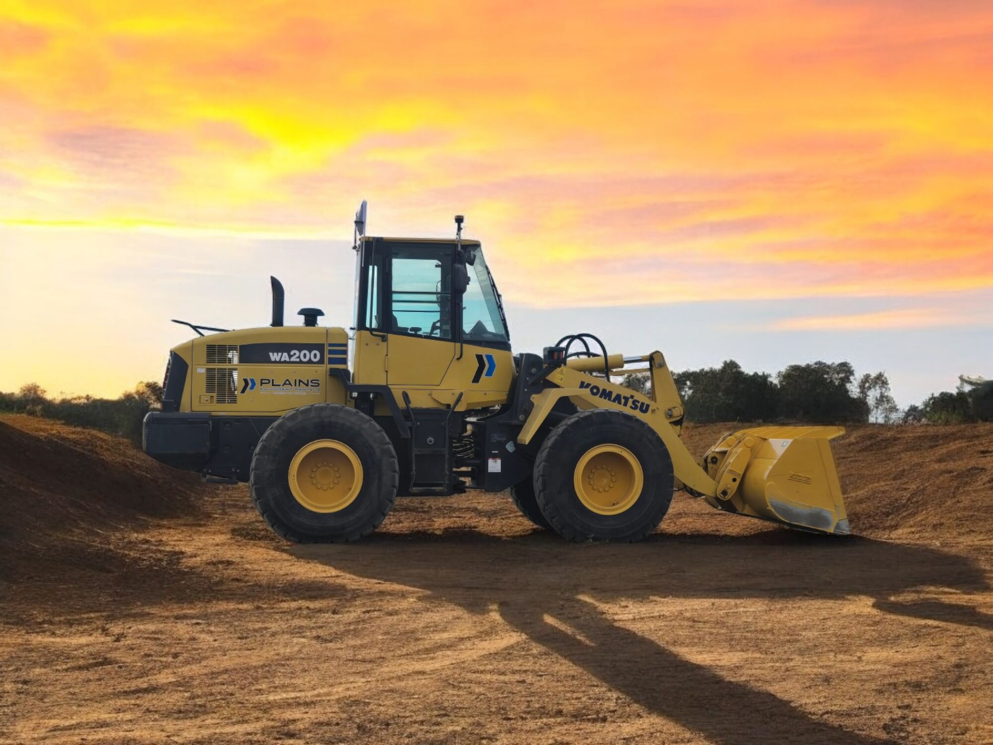 Komatsu-WA200-wheel-loader-from-Plains-Equipment-Rentals-on-a-construction-site-at-sunset-in-Western-Canada