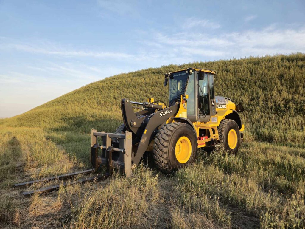 Angled shot of John Deere 524K-II loader with forks attachment, Plains Equipment Rentals, Canada