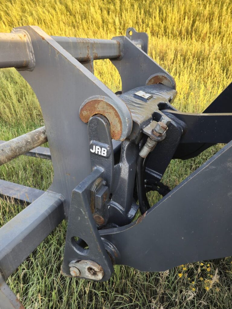 Close-up of JRB quick coupler attachment on John Deere 524K-II loader for sale in Western Canada