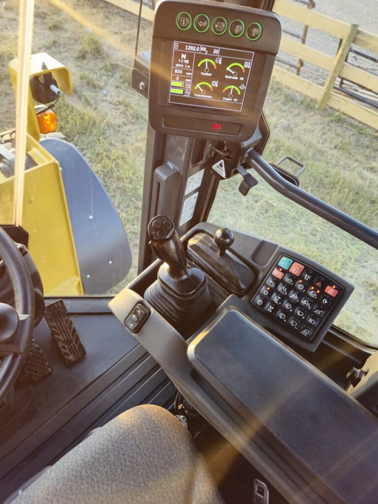 Control panel and joystick inside John Deere 524K-II wheel loader cab, Plains Equipment Rentals
