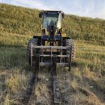 Front view of John Deere 524K-II loader with pallet forks, available for sale in Western Canada