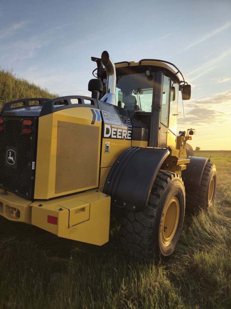 Rear angled view of John Deere 524K-II loader at sunset, Plains Equipment Rentals, Western Canada