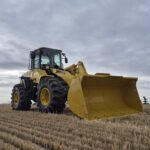2010 Komatsu WA250-6 side profile parked in Alberta field showing loader arm and bucket