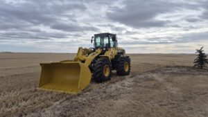 2010 Komatsu WA250-6 wheel loader with front bucket angled in Alberta