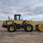 2010 Komatsu WA250-6 wheel loader side view in Alberta field showing overall condition