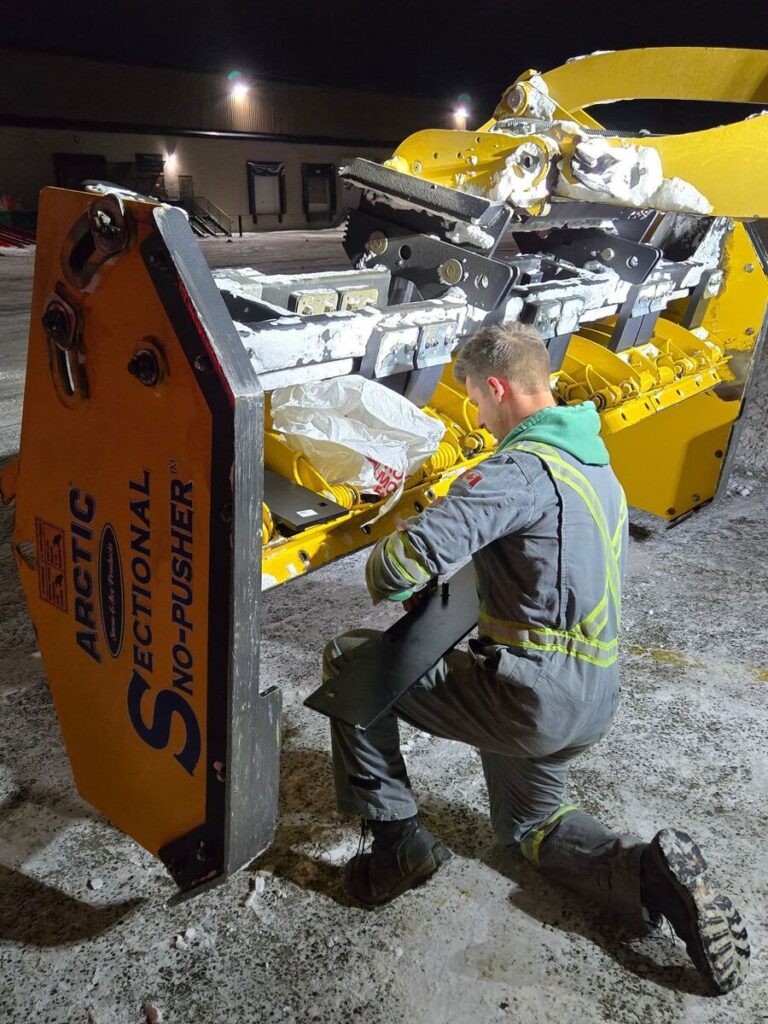 shawn-neels-repairing-arctic-snow-ice-snow-pusher-western-canada