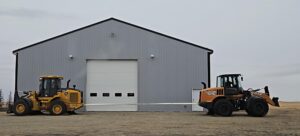 Two heavy loaders positioned outside industrial warehouse building comparison