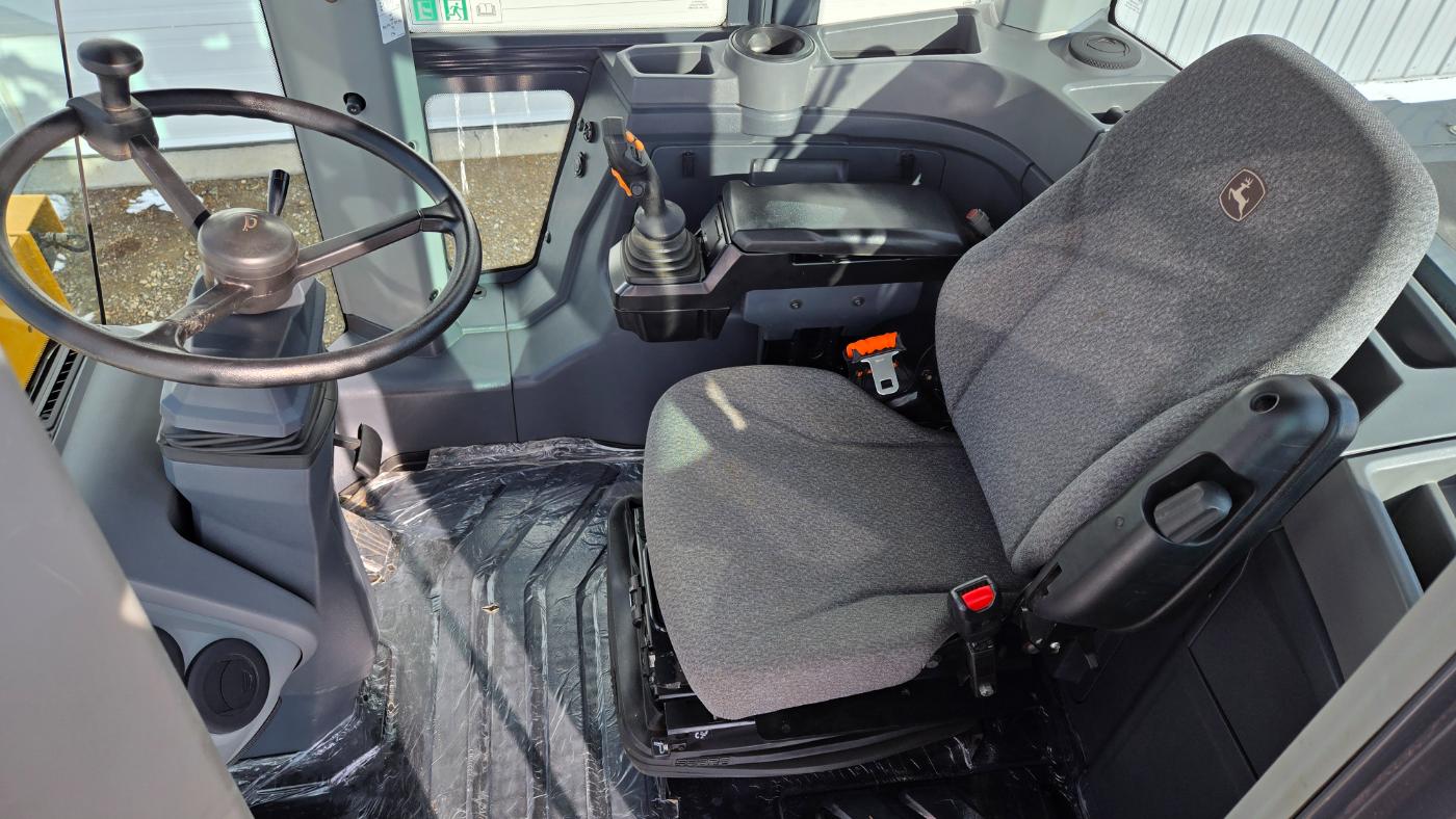 John Deere 444 loader cabin interior showing steering wheel and operator seat for western Canada equipment rental