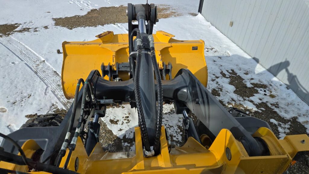 Yellow John Deere front-end loader with attachment for snow removal operations