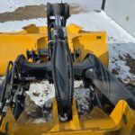 Yellow John Deere front-end loader with attachment for snow removal operations