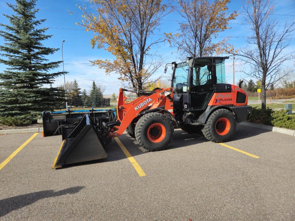 Kubota R640 wheel loader with front bucket attachment in parking lot