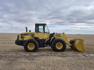 2010 Komatsu WA250-6 wheel loader side view in Alberta field showing overall condition