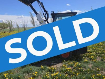 2022-bobcat-l28-small-articulated-loader-sold-western-canada-lifted-bucket-side-view-field